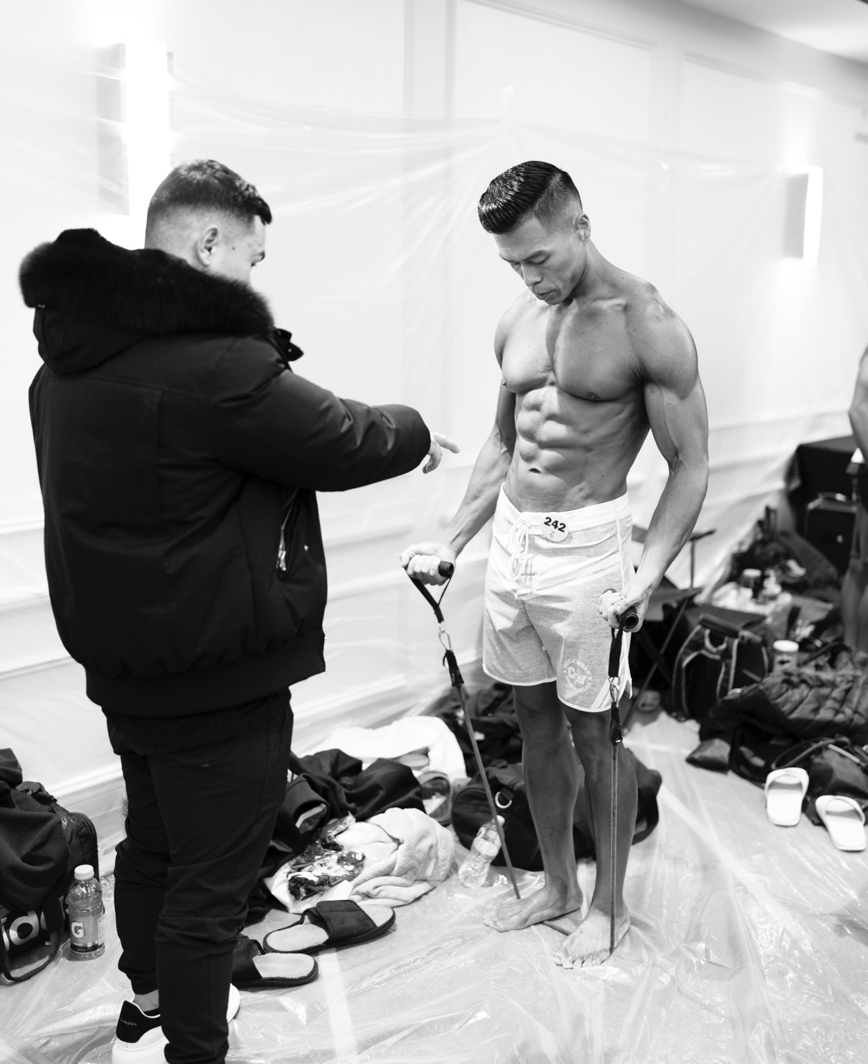 Backstage coaching support as an athlete warms up with resistance bands on show day