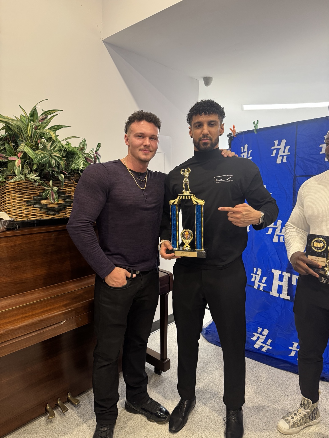 Two guests posing with a trophy at an awards event