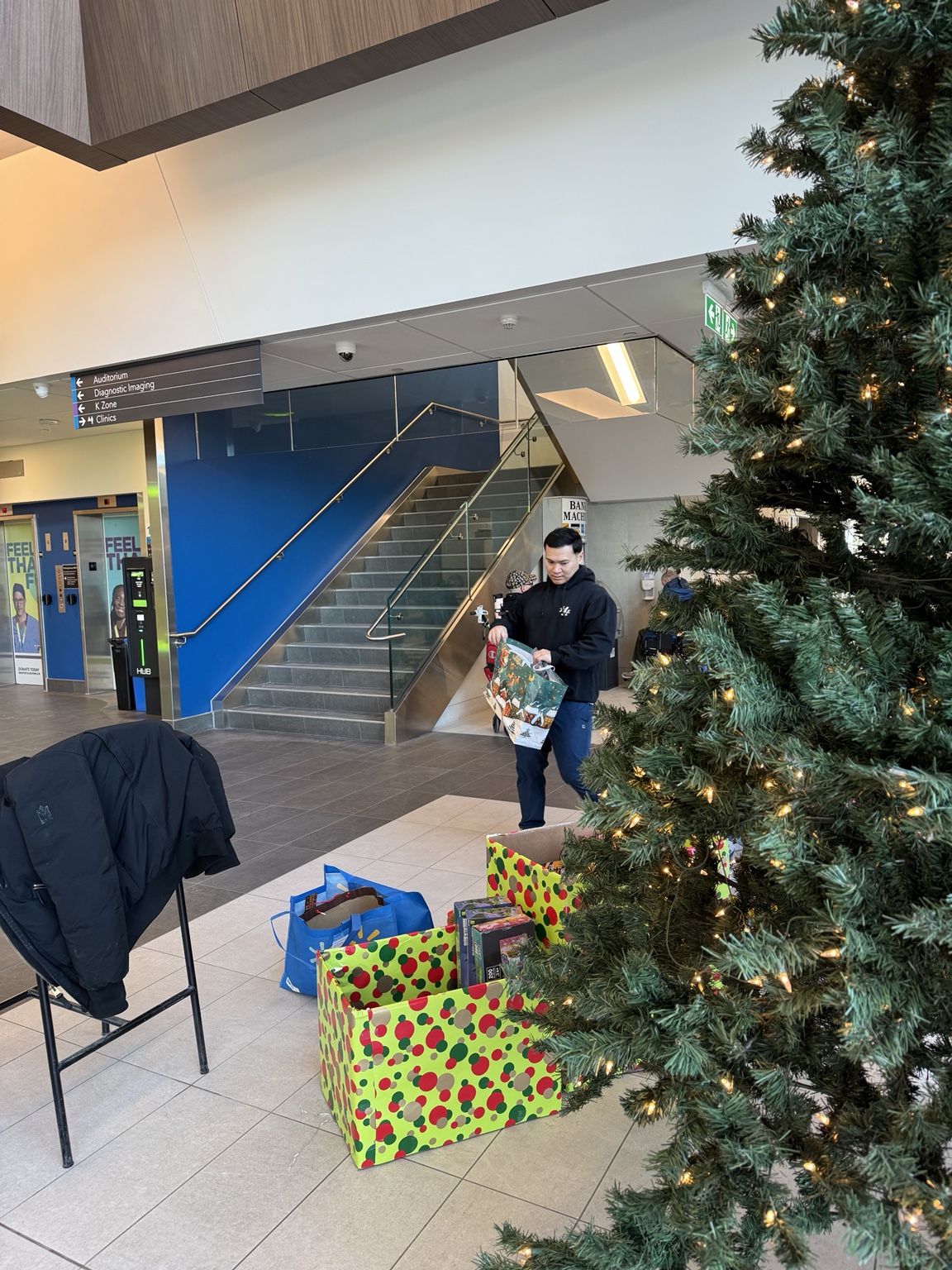 Gift bags beside a Christmas tree at a community centre