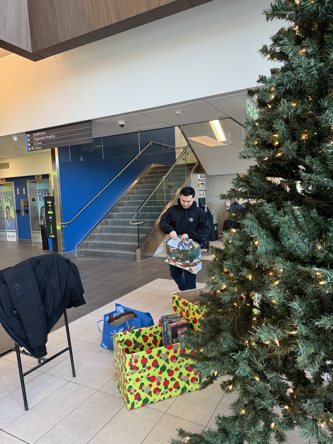 Team member beside donated gifts at a community centre